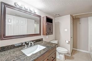 bathroom with vanity, tile patterned flooring, a textured ceiling, and toilet