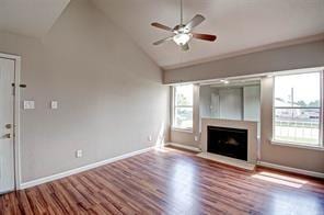 unfurnished living room with hardwood / wood-style flooring, ceiling fan, and high vaulted ceiling