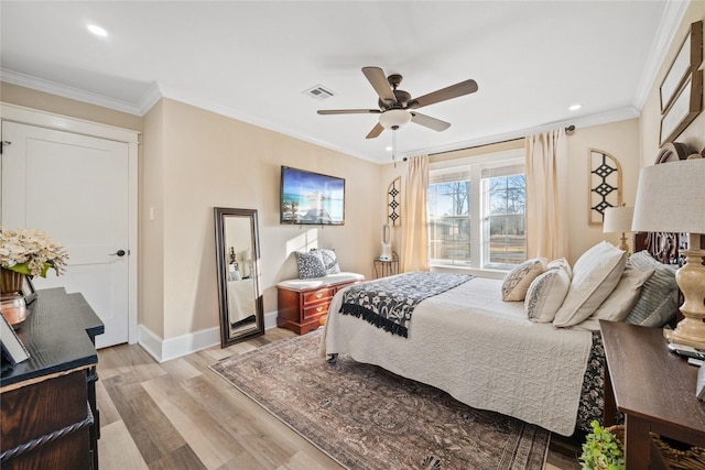 bedroom with ornamental molding, ceiling fan, and light wood-type flooring