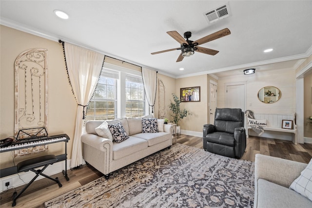 living room featuring hardwood / wood-style floors, crown molding, and ceiling fan