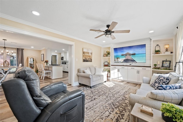 living room with crown molding, light hardwood / wood-style flooring, a textured ceiling, and ceiling fan with notable chandelier