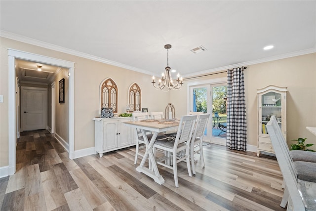 dining area featuring an inviting chandelier, ornamental molding, and light hardwood / wood-style flooring