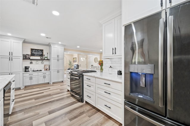 kitchen featuring white cabinets, light stone counters, gas stove, stainless steel refrigerator with ice dispenser, and light hardwood / wood-style flooring