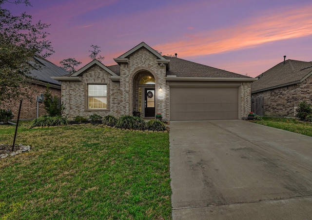 ranch-style house featuring a yard and a garage