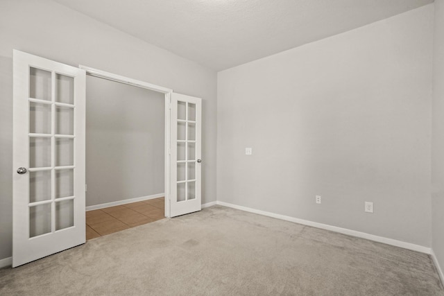 empty room featuring carpet floors and french doors