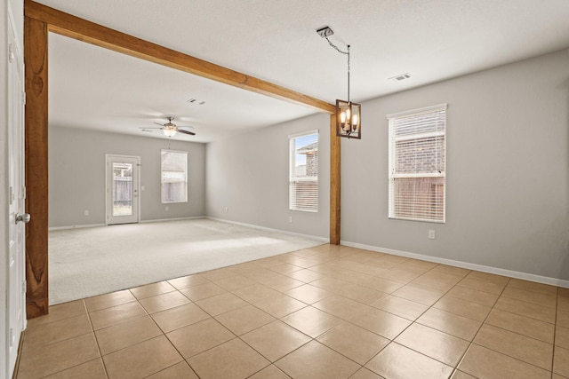 tiled empty room featuring ceiling fan with notable chandelier and beam ceiling