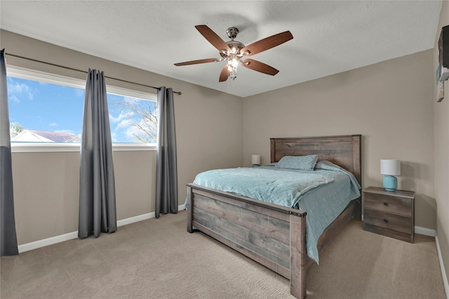 bedroom with baseboards, ceiling fan, and light colored carpet