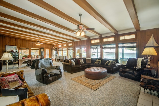 living area featuring vaulted ceiling with beams, ceiling fan, and wooden walls