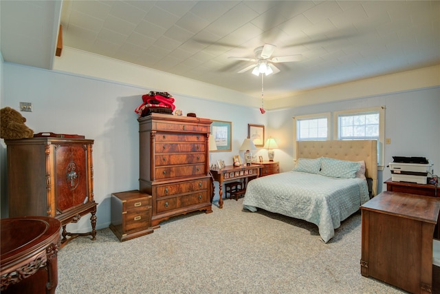carpeted bedroom featuring crown molding and ceiling fan