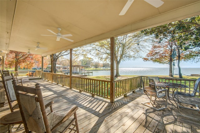 wooden deck with a water view and ceiling fan