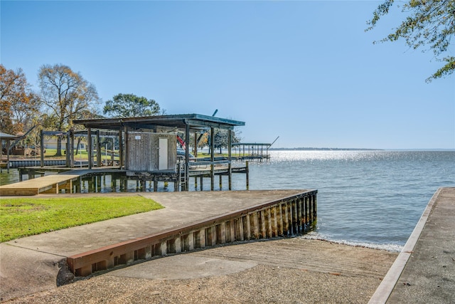 dock area with a lawn and a water view