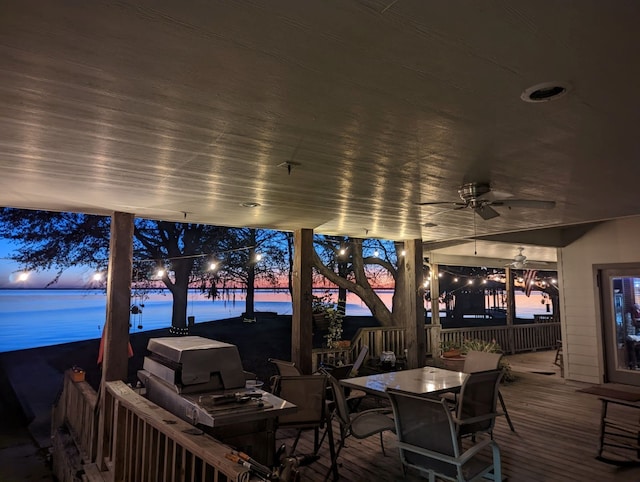 wooden terrace with outdoor dining space and ceiling fan