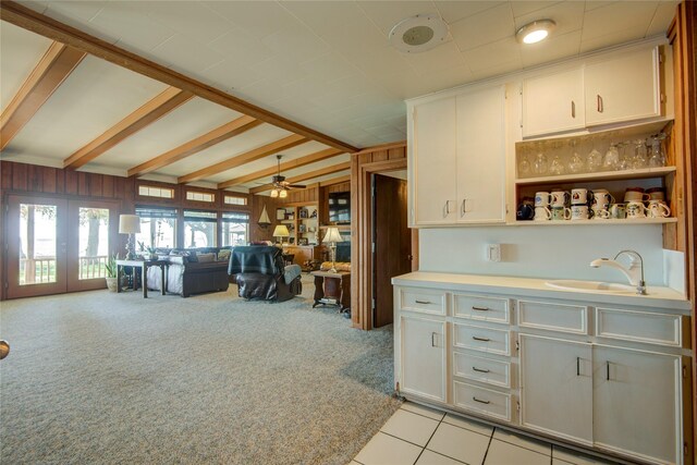 kitchen featuring a sink, ceiling fan, white cabinetry, and open floor plan