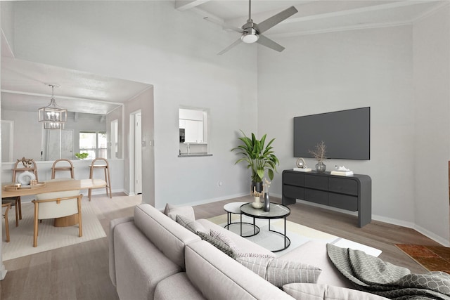 living room with crown molding, hardwood / wood-style flooring, and ceiling fan with notable chandelier