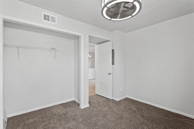 unfurnished bedroom featuring a closet and dark colored carpet