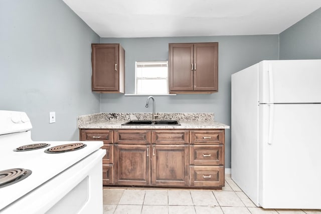 kitchen with light tile patterned flooring, sink, and white appliances