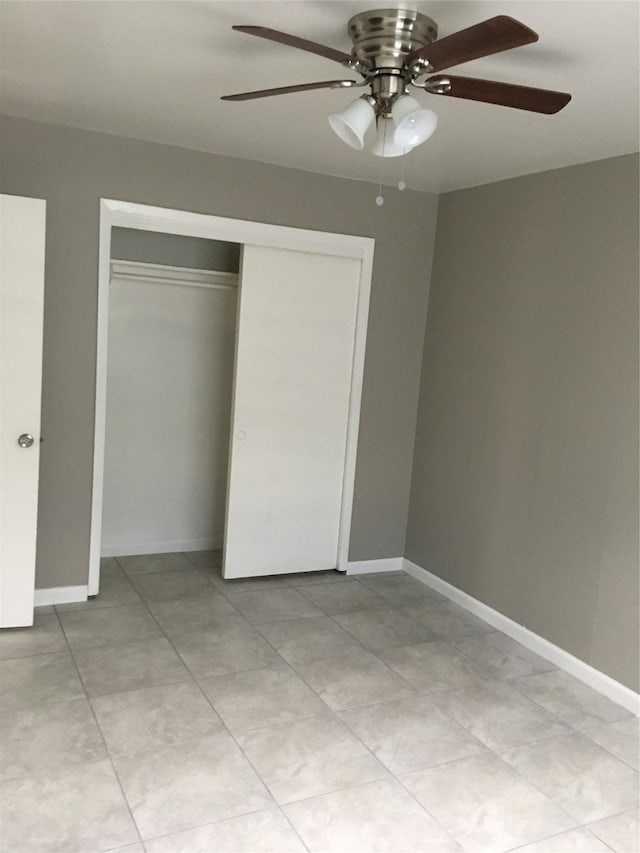 unfurnished bedroom with ceiling fan and a closet