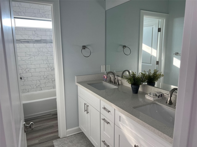 bathroom featuring vanity, hardwood / wood-style floors, and tiled shower / bath combo