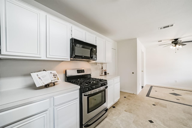 kitchen with ceiling fan, gas stove, and white cabinets