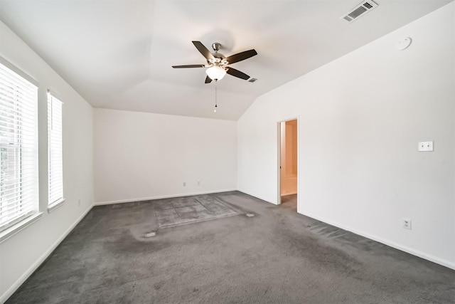 carpeted empty room with ceiling fan, lofted ceiling, and a wealth of natural light