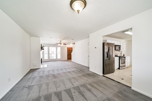 unfurnished living room with ceiling fan and light colored carpet