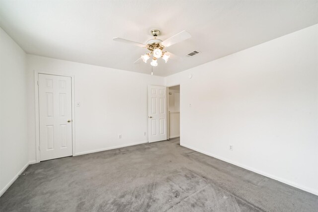 carpeted empty room featuring ceiling fan, visible vents, and baseboards