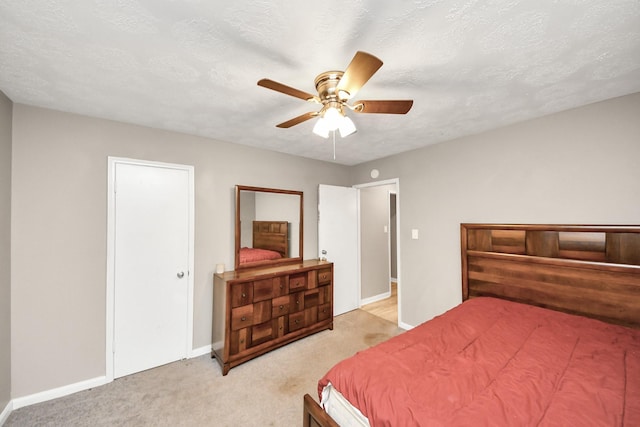 bedroom featuring ceiling fan, light carpet, and a textured ceiling