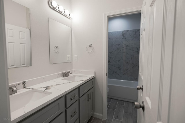 full bathroom with tiled shower / bath, vanity, and toilet