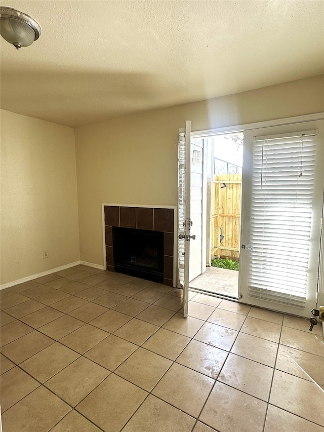 tiled entryway with a tiled fireplace and a textured ceiling