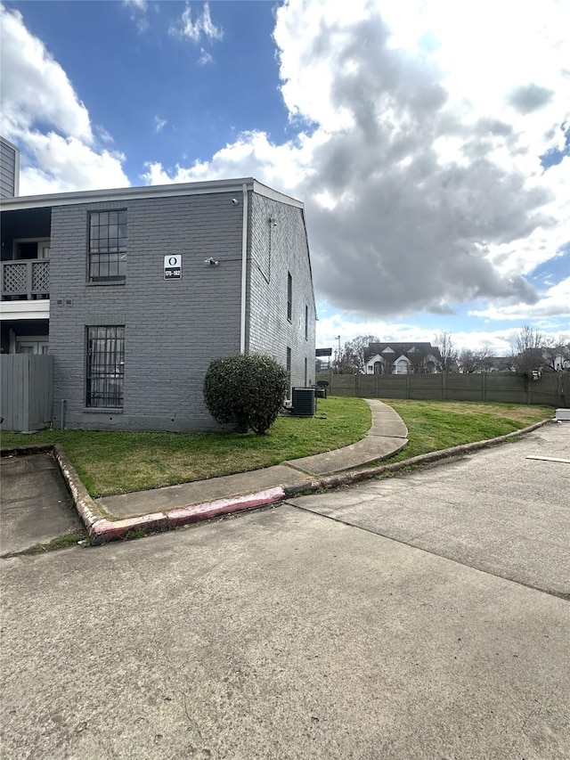 view of side of property with cooling unit and a yard