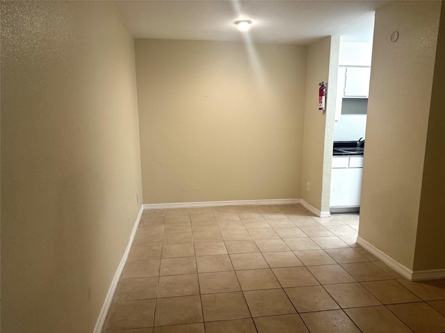 tiled empty room featuring sink