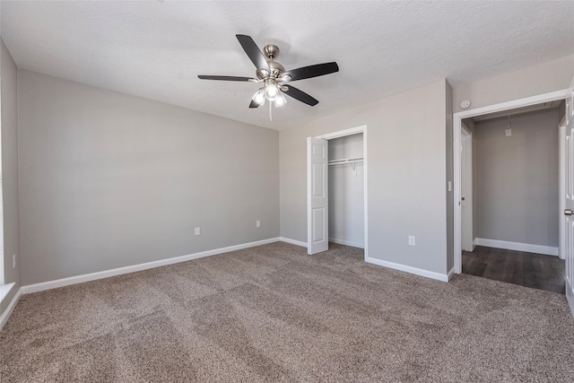 unfurnished bedroom with ceiling fan, a textured ceiling, dark carpet, and a closet