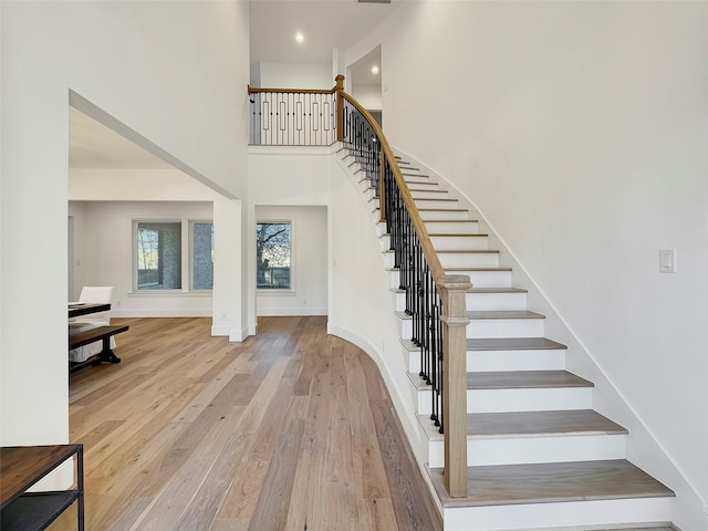 stairway featuring a high ceiling and wood-type flooring