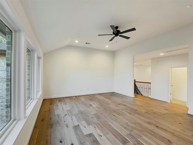 empty room with vaulted ceiling, ceiling fan, and light wood-type flooring