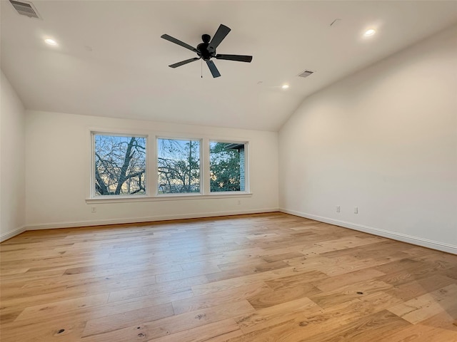 spare room with vaulted ceiling, ceiling fan, and light wood-type flooring