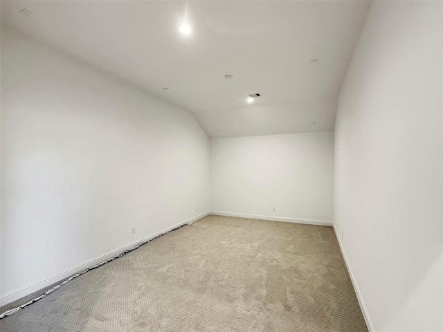 carpeted spare room with lofted ceiling