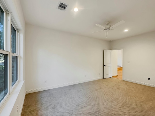 carpeted spare room featuring ceiling fan