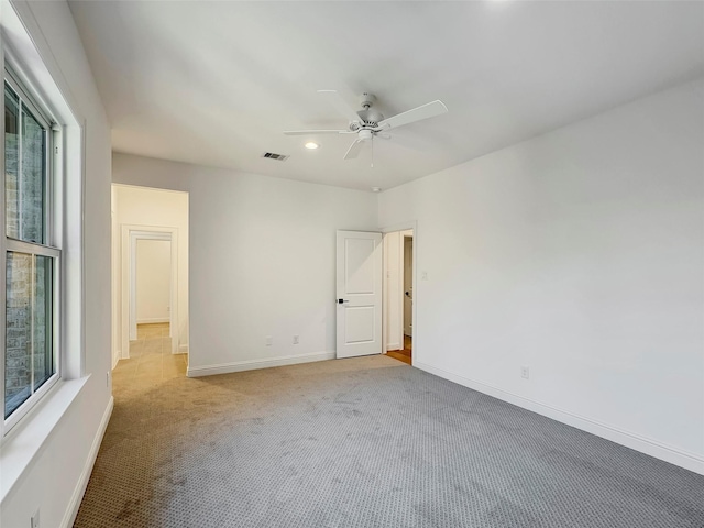 empty room with ceiling fan and light colored carpet