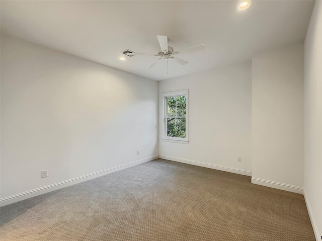 carpeted spare room with ceiling fan