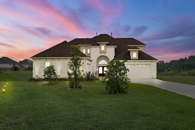 view of front of house with a garage and a lawn