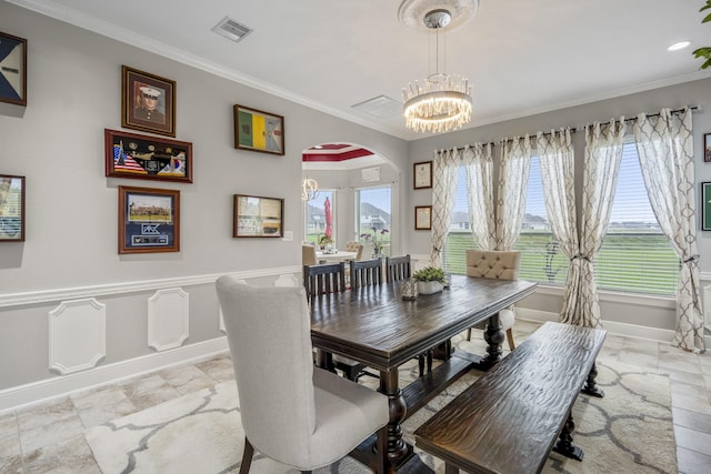 dining space featuring crown molding, plenty of natural light, and a chandelier