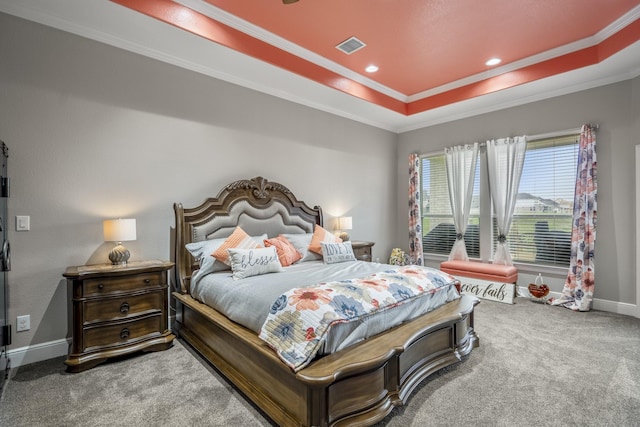 carpeted bedroom with a tray ceiling and ornamental molding