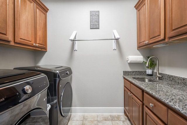 laundry room with cabinets, washing machine and clothes dryer, and sink