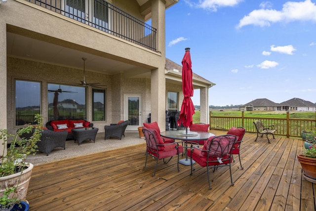 deck with outdoor lounge area and ceiling fan