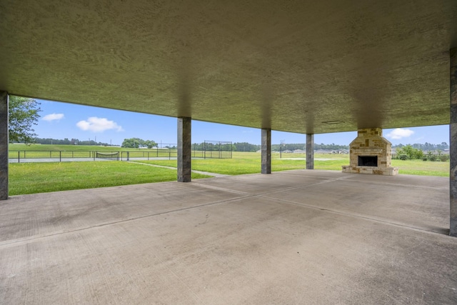 view of patio with a rural view and an outdoor stone fireplace