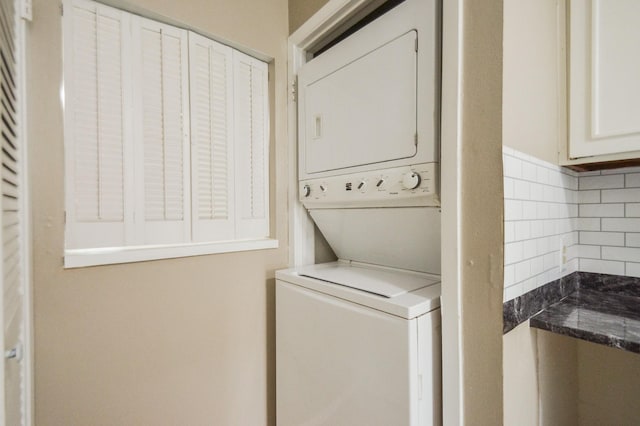 washroom featuring stacked washer / drying machine