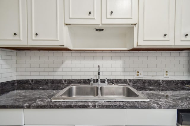 kitchen with tasteful backsplash, dark stone countertops, sink, and white cabinets