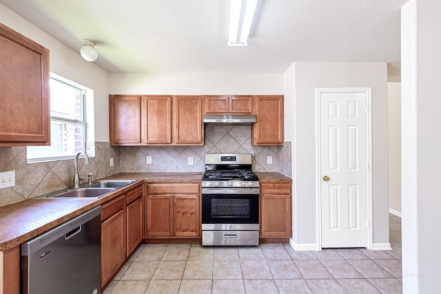 kitchen with light tile patterned flooring, dishwasher, sink, decorative backsplash, and stainless steel gas range