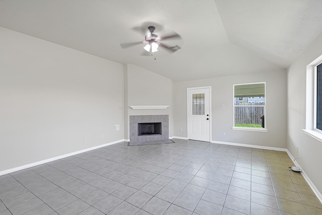 unfurnished living room featuring lofted ceiling, a fireplace, tile patterned floors, and ceiling fan