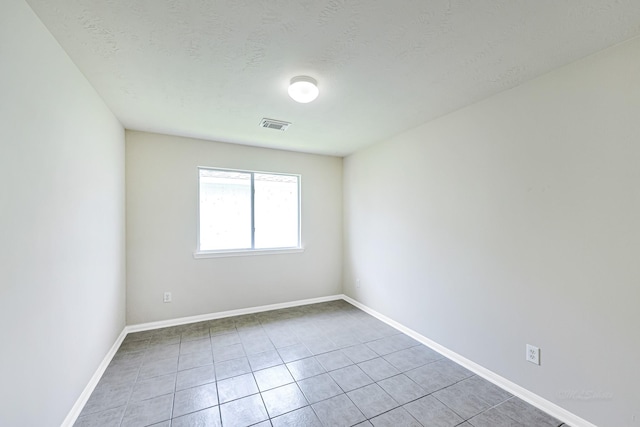 unfurnished room with tile patterned floors and a textured ceiling